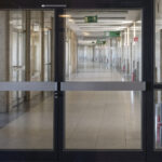 Desolate marble floored corridor at former airport Berlin Tempelhof  with large glass doorways for background in urban public commerce