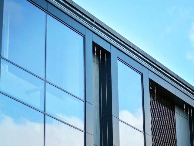 Facade fragment of a modern office building. Exterior of glass wall with abstract texture.